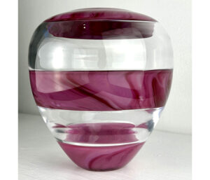 Image of a glass vase in front of a white background. The vase is comprised of five stripes, three pink and two clear. The pink stripes have dark pink streaks throughout them.