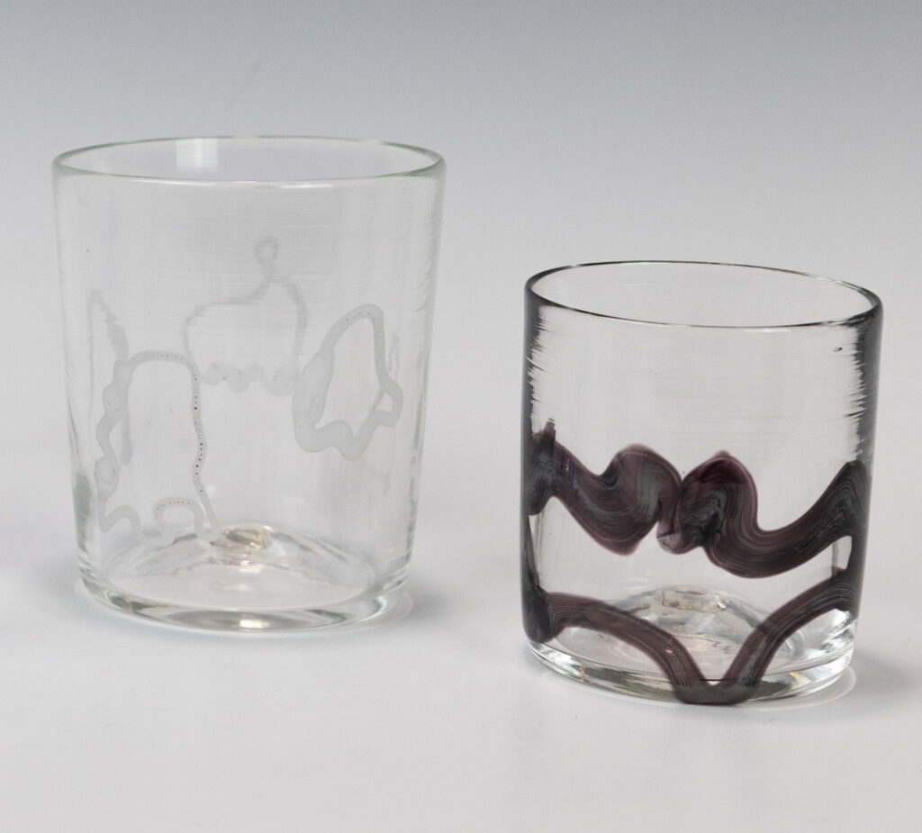 Image of two clear glass cups. The cup on the left has four white ghost outlines while the cup on the left has a large black outline of a bat.